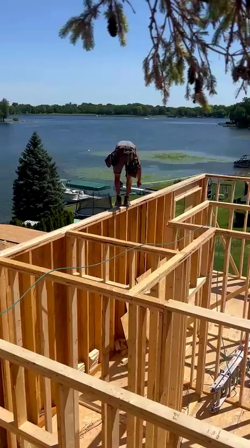 Framer on the top plate of a lakefront home with walls framed, White Lake MI