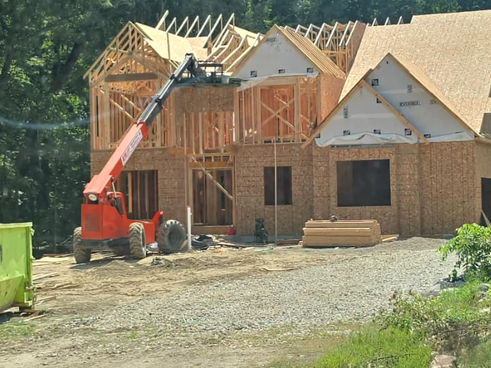 Two story custom home framed, roof trusses set, telehandler on site, Novi MI